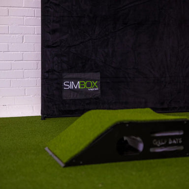 Black mat with a SIMBOX label on a green surface against a white brick wall